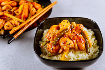 Wall Mural - Rice with stir fry chicken and vegetable on black square plate. Chinese cuisine.