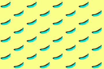 Wall Mural - Minimal repetitive patter made of blue bananas on yellow background.