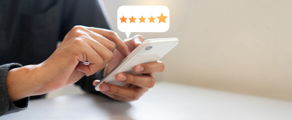 close up on man hand press on smartphone screen with gold five star rating feedback icon and press l