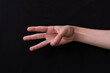 © Fernando - hand showing three fingers on a black background