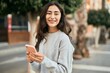 © Krakenimages.com - Young middle east girl smiling happy using smartphone at the city.