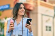 © Krakenimages.com - Young hispanic tourist woman using smartphone and eating ice cream at the city.