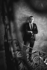 Poster - Vertical shot of a white Caucasian man wearing a classic black suit and posing for a picture