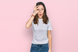 © Krakenimages.com - Young beautiful woman wearing casual white t shirt doing ok gesture shocked with surprised face, eye looking through fingers. unbelieving expression.