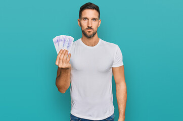 Sticker - Handsome man with beard holding 20 swedish krona banknotes thinking attitude and sober expression looking self confident