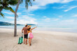 © Kittiphan - Young couple traveler with luggage relaxing and enjoying at beautiful tropical sand beach, Summer vacation and Travel concept