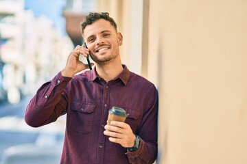 Poster - Young hispanic man talking on the smartphone and drinking coffee at the city.