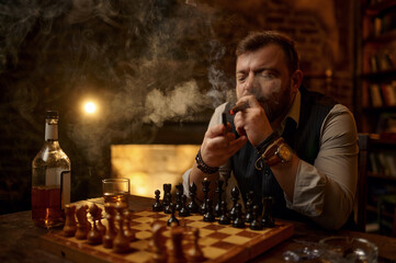 Man smokes a cigar, smoker leisures at chessboard