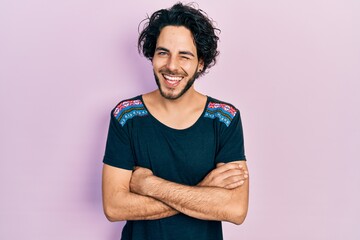 Poster - Handsome hispanic man with arms crossed gesture winking looking at the camera with sexy expression, cheerful and happy face.