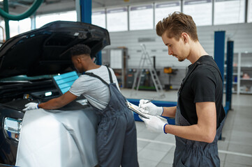 Wall Mural - Two male workers repairs engine, car service