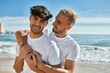 © Krakenimages.com - Young gay couple smiling happy hugging at the beach.