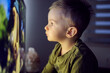 © Dusan Petkovic - Modern parenting. Close up shot of a baby boy is sitting right in front of the TV and staring at a cartoon screen. Entertaining a child before going to bed at night in the age of advanced technology