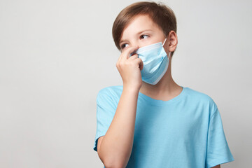 Wall Mural - School boy with face mask on white background