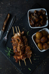 Poster - Fried meat on a skewer with baked potatoes and mushrooms