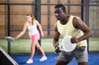 © JackF - Sporty afro american man in yellow t-shirt playing padel tennis indoor