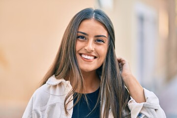 Young hispanic girl smiling happy standing at the city.