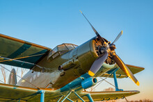 An Old Passenger Military Aircraft With A Propeller And Blades, From The Time Of The Second World War, Stands In The Airfield Clearing Against The Blue Sky