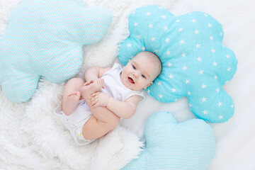 Wall Mural - baby boy lying in bed before going to bed, cute, laughing, six-month-old, smiling little baby