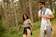 © BGStock72 - Smiling young couple walking with backpacks in the forest