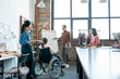 © pressmaster - Group of designers listening to disable male colleague by whiteboard