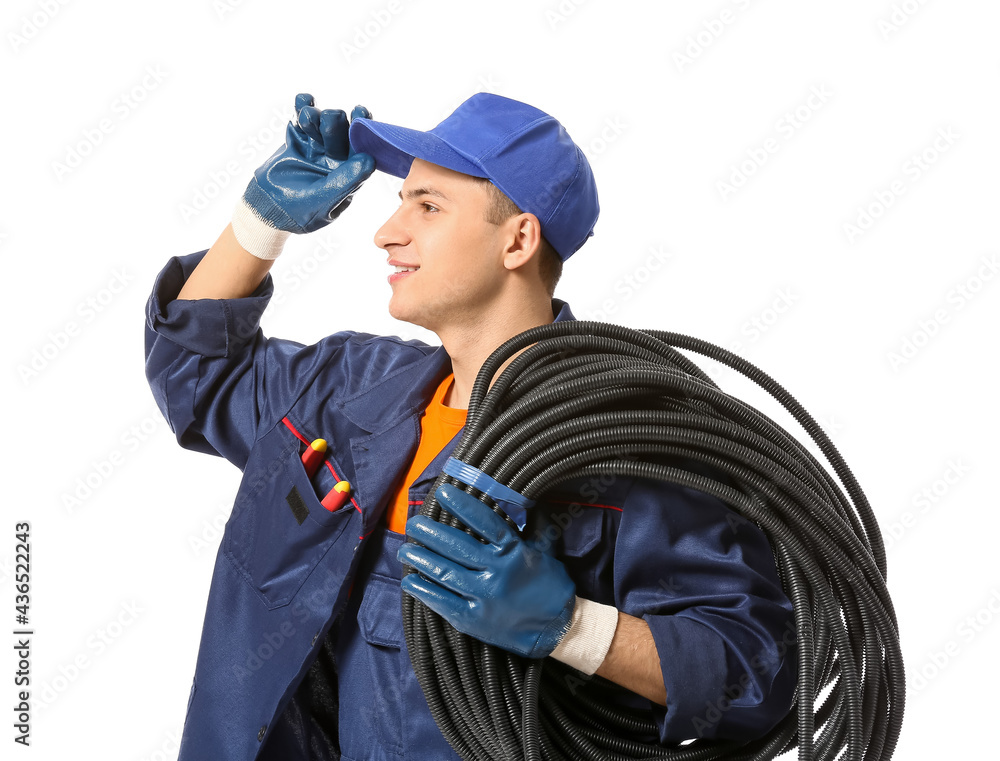 Young electrician with cables on white background