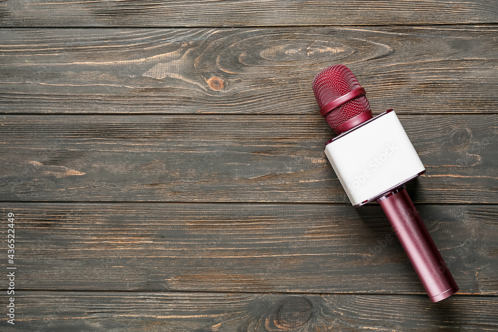 Modern microphone on wooden background