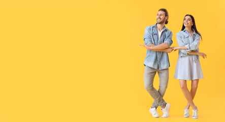 Poster - Happy young couple dancing on color background