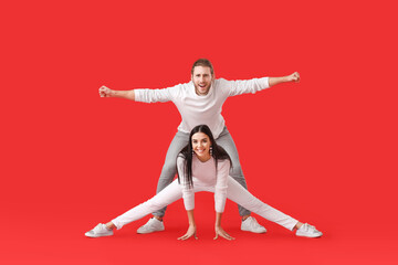 Wall Mural - Happy young couple dancing on color background