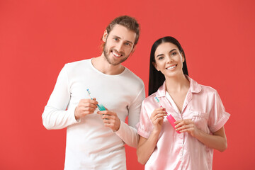 Poster - Young couple with tooth brushes on color background