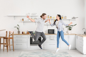 Wall Mural - Happy young couple dancing in kitchen