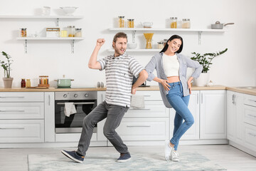 Wall Mural - Happy young couple dancing in kitchen