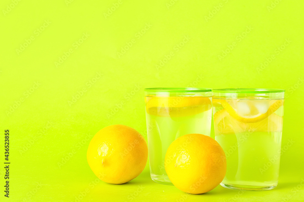 Glasses of tasty cold lemonade on color background