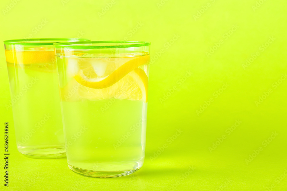 Glasses of tasty cold lemonade on color background