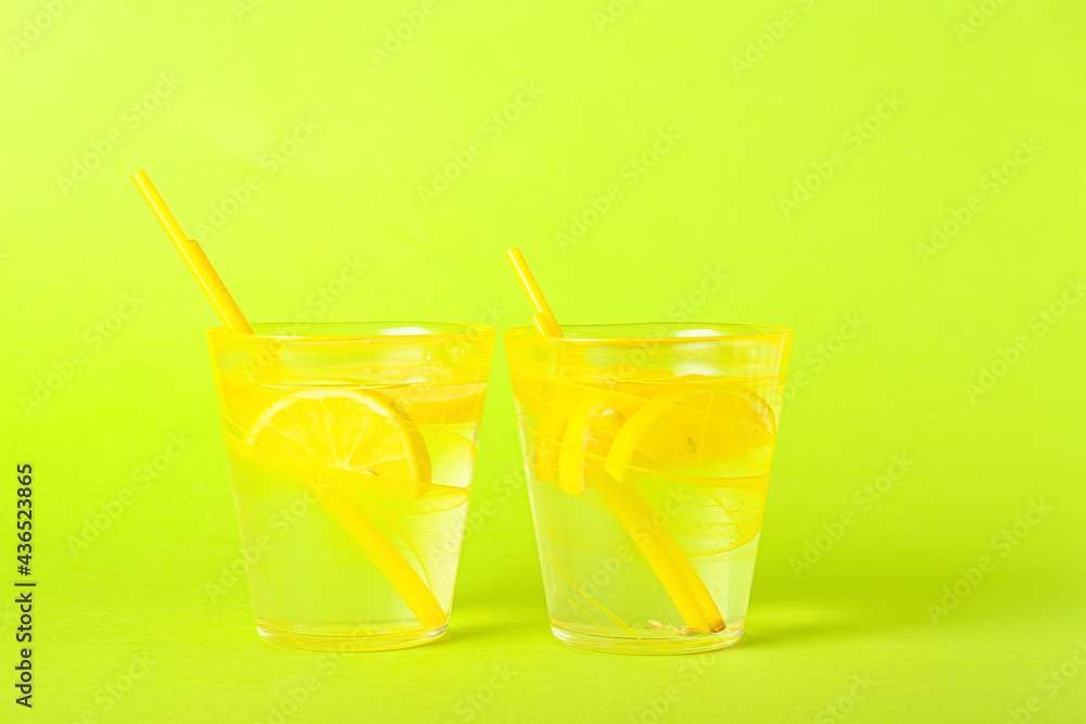 Glasses of tasty cold lemonade on color background