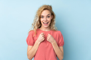 Canvas Print - Young blonde woman isolated on blue background celebrating a victory