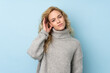 © luismolinero - Young blonde woman wearing a sweater isolated on blue background having doubts