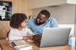 © Stock 4 You - Happy african american family doing home task. Caring father help little daughter with school subject homework. Homeschooling conducted by parent, distant e-study and e-learning concept