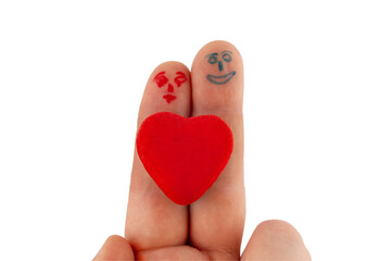 two fingers of the hand with painted faces male and female and a big red heart between them. relationship concept. copy space.