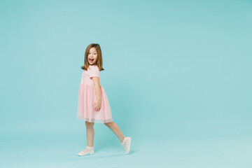 Wall Mural - Full size body length side view little fun cute kid girl 5-6 years old wears pink dress dancing isolated on pastel blue color background child studio portrait. Mother's Day love family people concept.