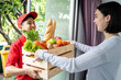Postman delivery deliver groceries food box to customer girl at home.