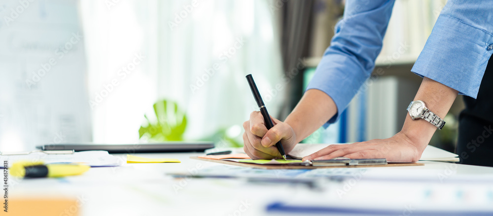 Hand of Businesswoman work in office write paperwork on table with pen - obrazy, fototapety, plakaty 