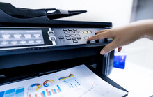 Office Worker Print Paper On Multifunction Laser Printer. Copy, Print, Scan, And Fax Machine In Office. Modern Print Technology.  Photocopy Machine. Document And Paper Work. Professional Scanner.