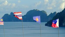 The Blowing Flags Of ASEAN Community - Thailand, Malaysia, And The Republic Of Philippines  -Fluttering Freely In Sea Background, Mountains, And Blue Sky. And Beautiful Scenery Of The Island.
