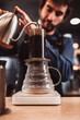 © andrey gonchar - Pressurized coffee brewing using an aeropress - the barista presses the piston