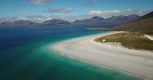 4k Aerial Footage Of Luskentyre Beach, Isle Of Lewis, Outer Hebrides, Scotland. Sunny Day With Blue Sky And White Clouds. White Sand, Turquoise And Blue Water, Sand Dunes, Mountains. Stunning Scenery.
