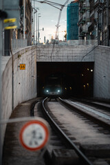 Sticker - Vertical shot of an electric train in a tunnel on the background of buildings in Porto, Portugal