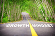 Growth mindset written on asphalt road surface. Self development to success concept and challenge keep moving idea
