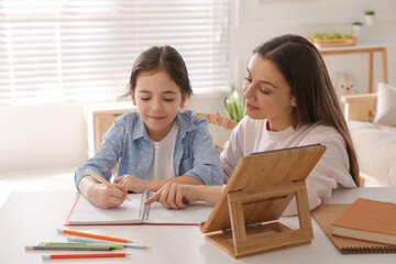 Sticker - Mother helping her daughter with homework using tablet at home