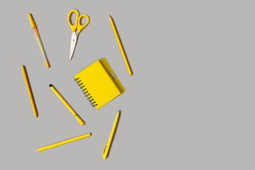 Yellow stationery on gray background. Flat lay.