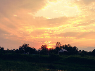 Green hill at the time of sunset and beautifull view of clouds in the sky with yellow bright light